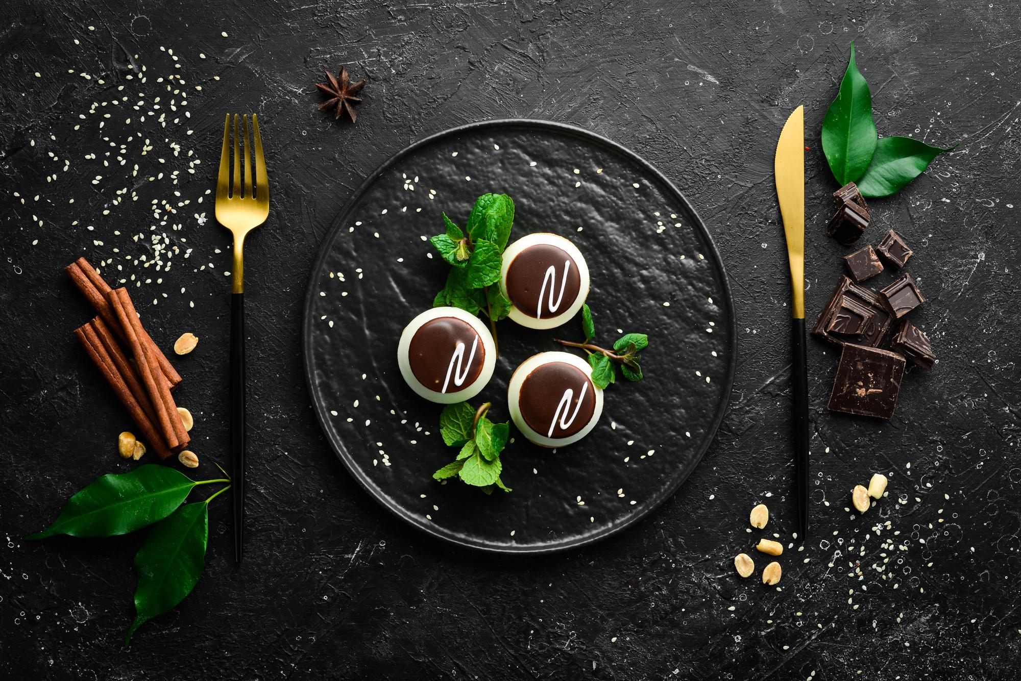 Plated dessert with gold leaf on dark plate
