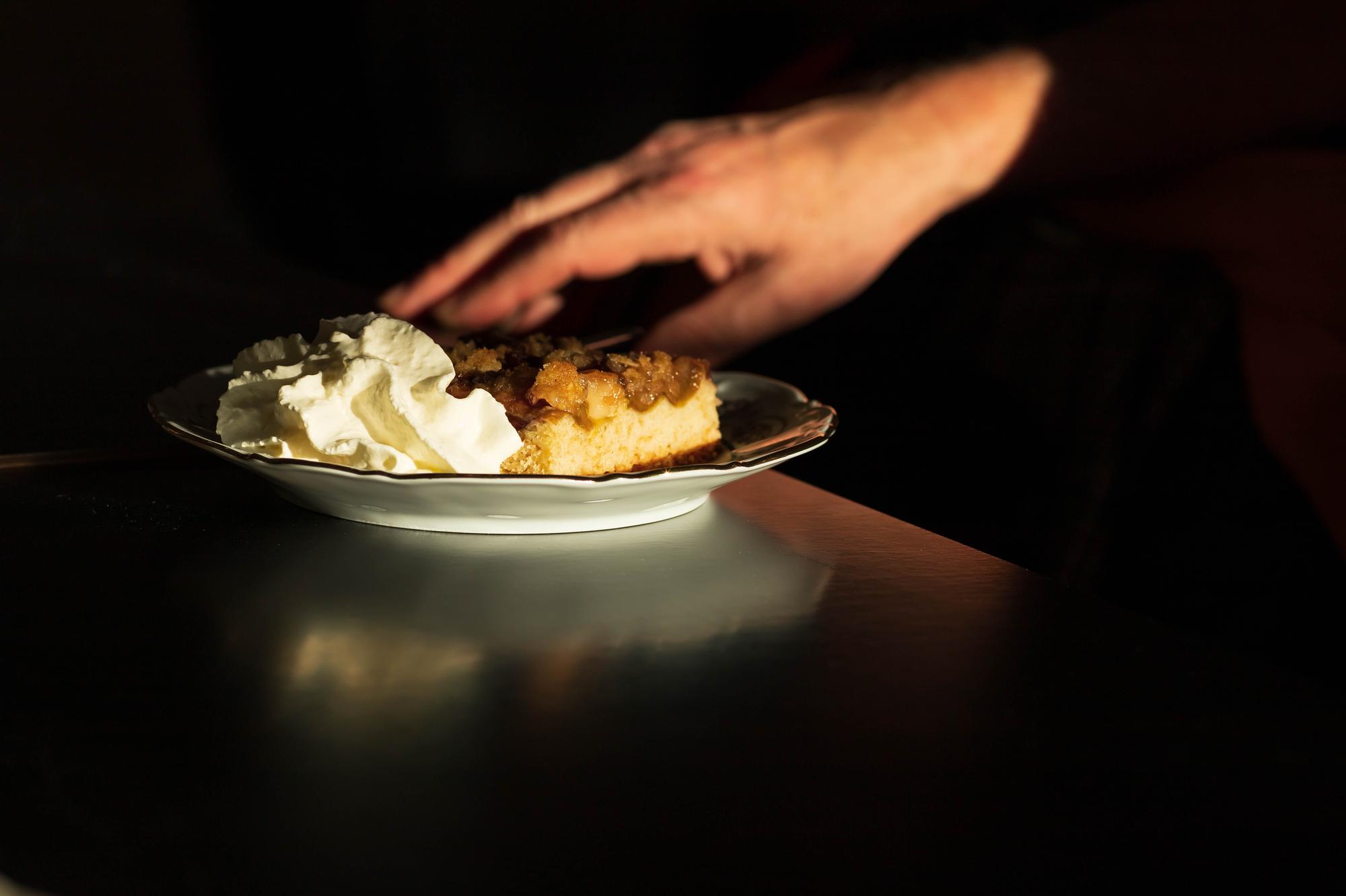 Chef arranging plated dish on dark table
